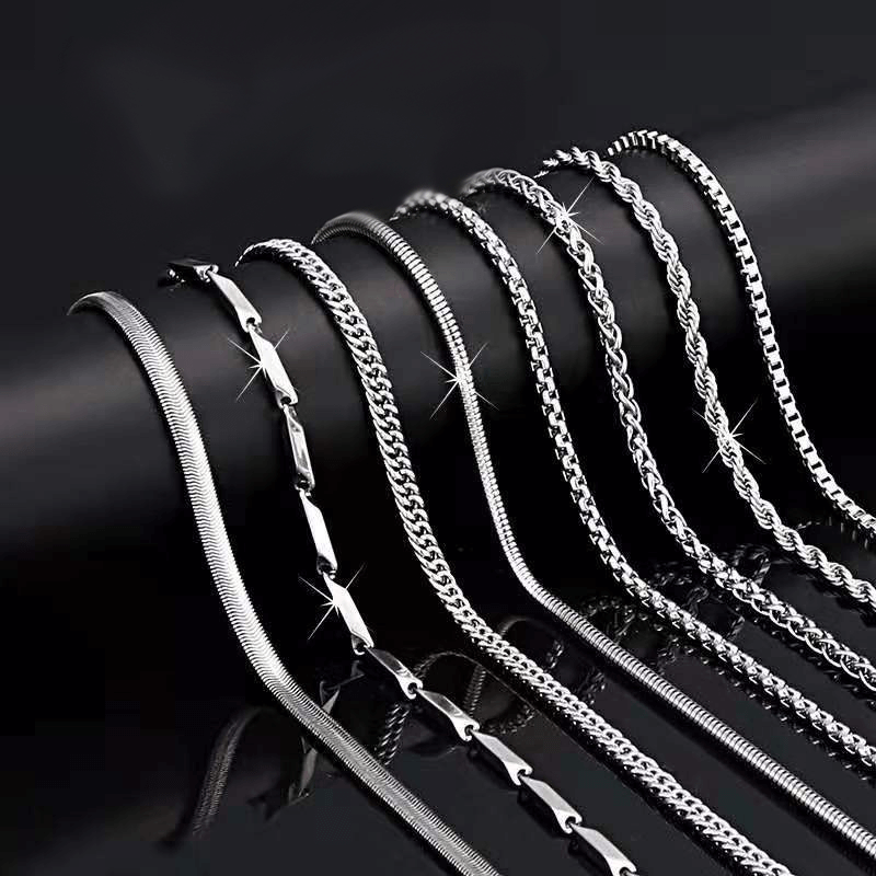 Various sterling silver Figaro chain necklaces displayed in elegant arrangement, showcasing individual lengths and styles.