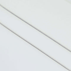 Close-up of solid 925 sterling silver snake chain necklaces in various thicknesses on white background.