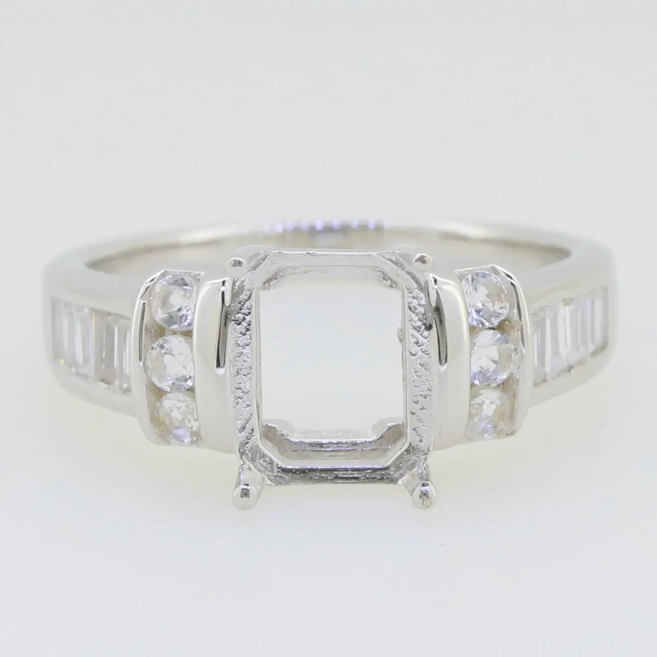 Sterling silver semi mount ring setting for 9X7mm emerald, featuring white topaz accents and polished finish.