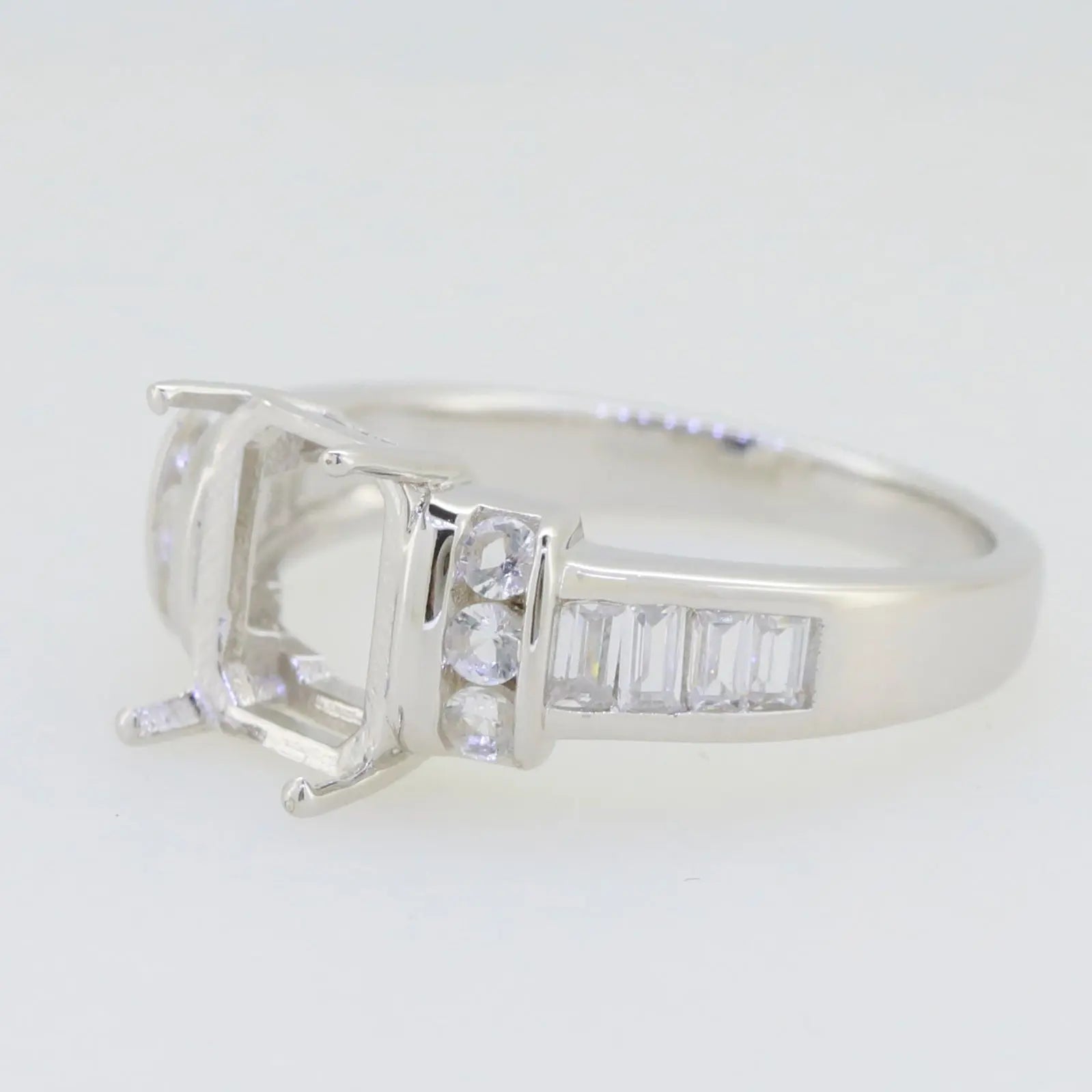 Sterling silver semi mount ring setting featuring a 9x7mm emerald-cut design with white topaz accents.