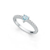 Silver ring with a central blue gemstone and smaller diamonds on a white background