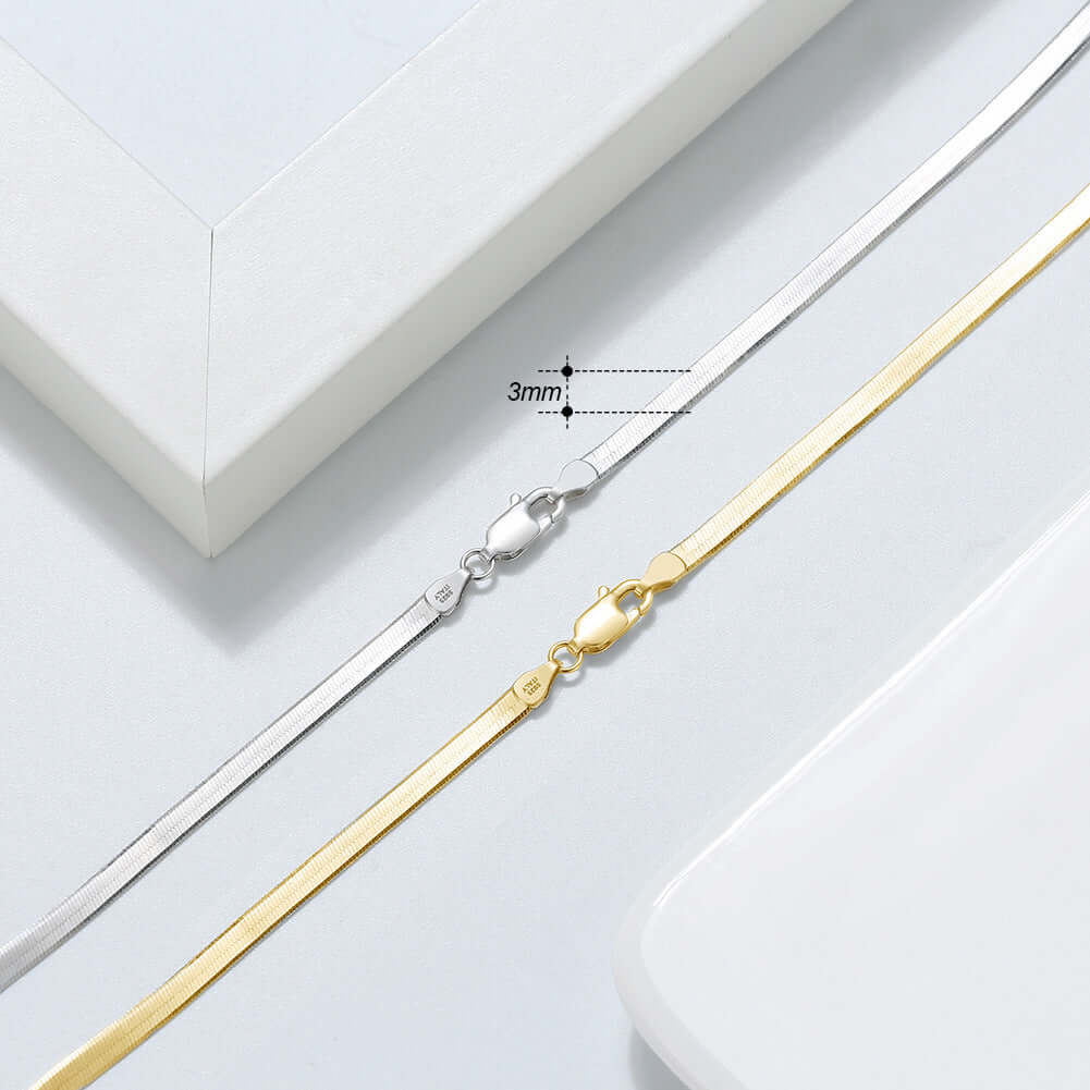Close-up of 3mm Sterling Silver and Gold Snake Bone Chain clasps on a minimalist background, showcasing elegance.